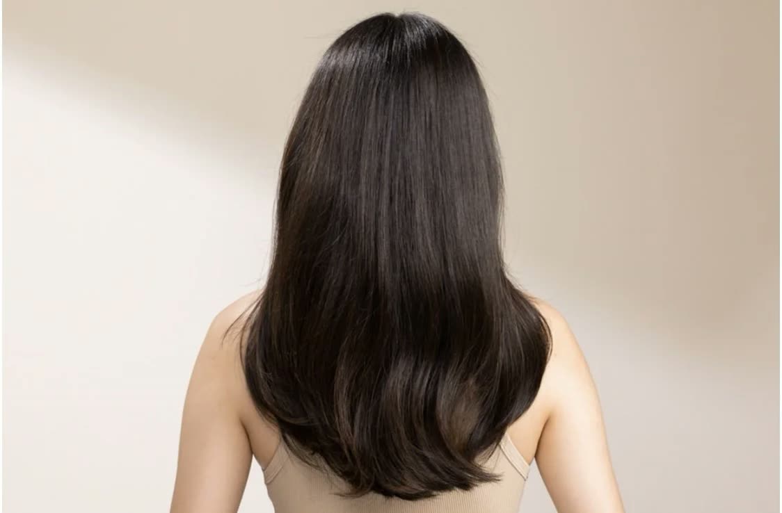Back view of long, straight dark brown hair over bare shoulders
