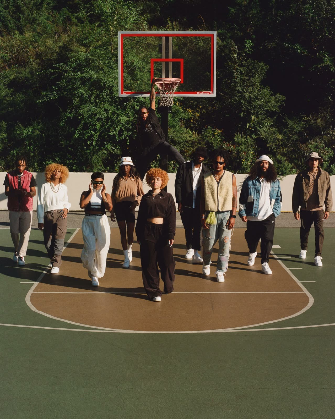 Group in white Air Force 1s walks across a basketball court, Ice Spice in front in black
