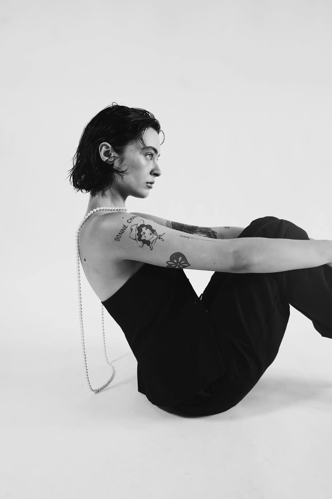 Black and white: Reilly Hail sits in profile in a black strapless top, pearl strands down the back