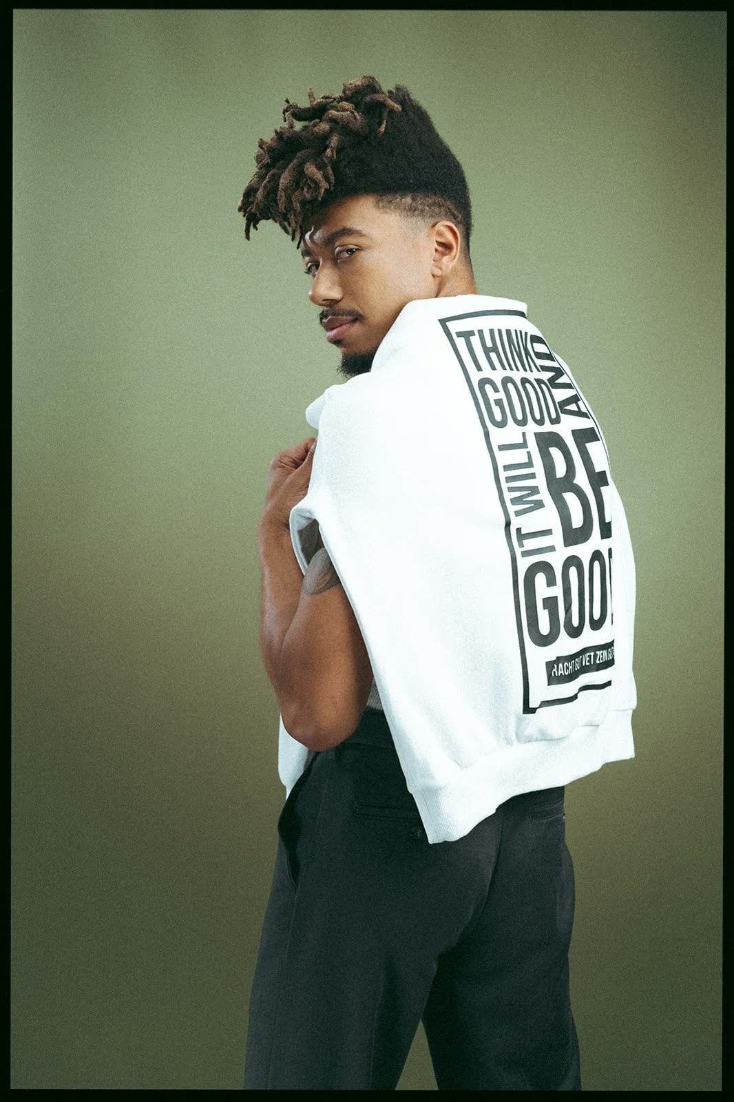 Man shows the back of a white hoodie printed Think Good and It Will Be Good